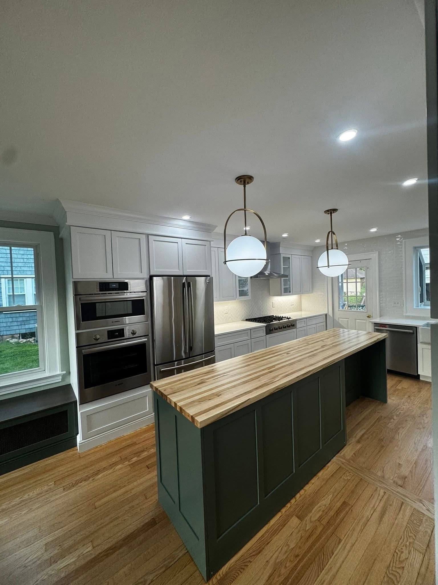 Kitchen island with pendant lighting and stainless appliances
